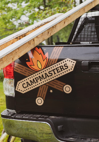 Campmasters logo on the tailgate of a campmasters maine pickup truck with dock boards on it.